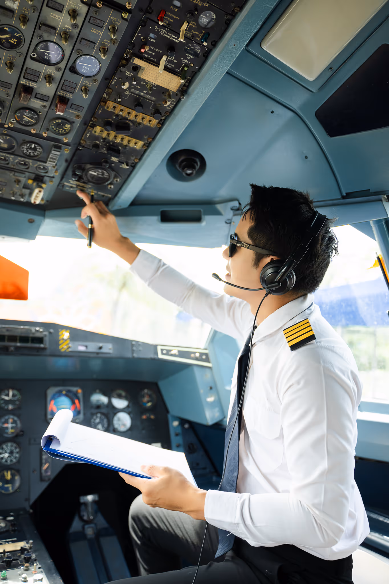Pilot in cockpit using flight checklists